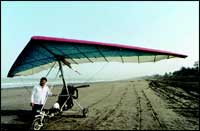 Dr. Behramshah Mazda stands proudly with his ultralight aircraft on Dahanu beach.
