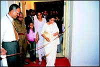 Asha Bhosle cutting a ribbon to open the exhibition of the UpperCrust Show, while Farzana Contractor and niece Zahra Kara look on.