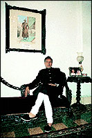 Mir Jaffar Imam, the Darbar of Kamadhia and scion of His Highness Nawab Mir Jafur Alee Khan of Surat, beneath whose portrait he is sitting in royal splendour at the familys mansion   Belha Court in Bombay.