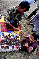 A young devotee gets a mehendi job done outside the temple.