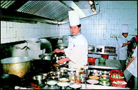 Chef Pempa Tsering in the Holiday Inn kitchen and, above, at the Sampan.