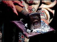 The heavy metal hammer crashes down on the leather pouch to make a tissue-thin sheet of varq.